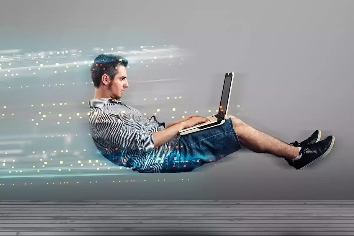How To Make Your WordPress Website Blazing Fast Featured Image | Man levitating in the air, slightly off the ground while typing on a laptop - Juan Rojo Design Toronto