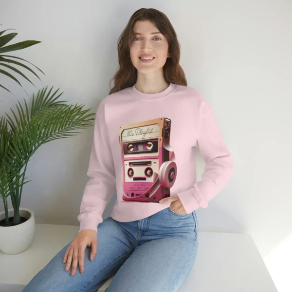 80s Playlist Sweatshirt Unisex, 80s retro hoodie, 80s style hoodie, 80s retro hoodie and Gen X | Picture of white woman wearing a pink sweatshirt with the graphic of a tape player with headphones sitting on top of it and on the tape label the words 80s Playlist have been written - Juan Rojo Design Toronto