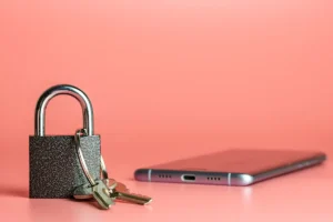 Do I Really Need a Privacy Policy on My Website? | concept image showing a lock with keys position in front of a mobile phone on a pink background - Juan Rojo Design Toronto