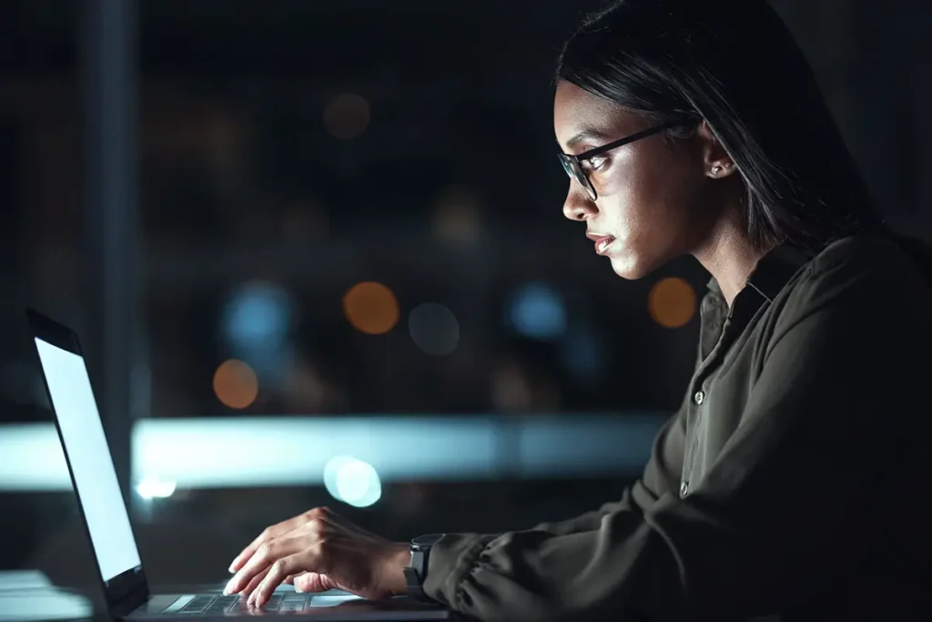 SEO Service Provider | Picture of woman looking at a laptop screen in a dark room - Juan Rojo Design Toronto